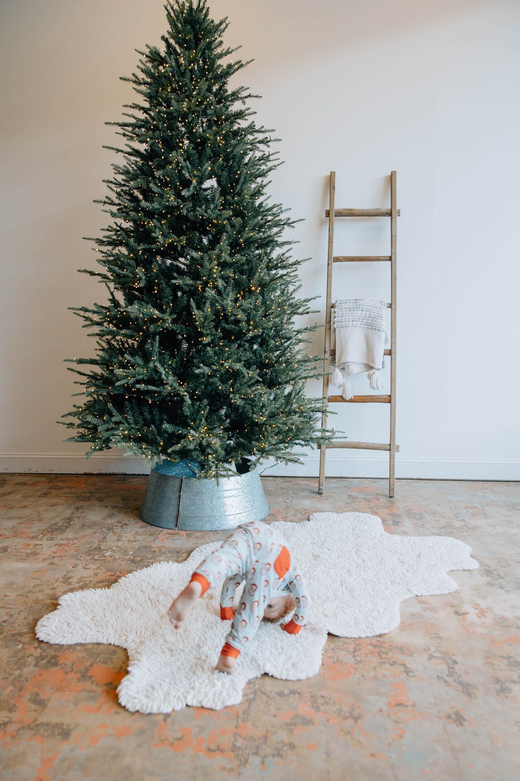 Holiday tree with a ladder and white rug