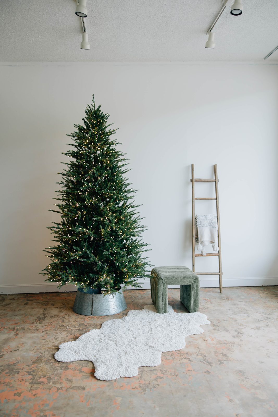 Holiday tree set with a wooden ladder, green stool and white rug