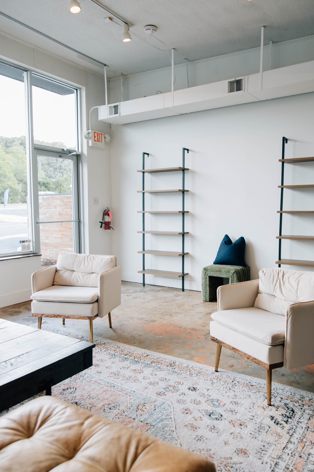Cream armchairs, shelves and a window
