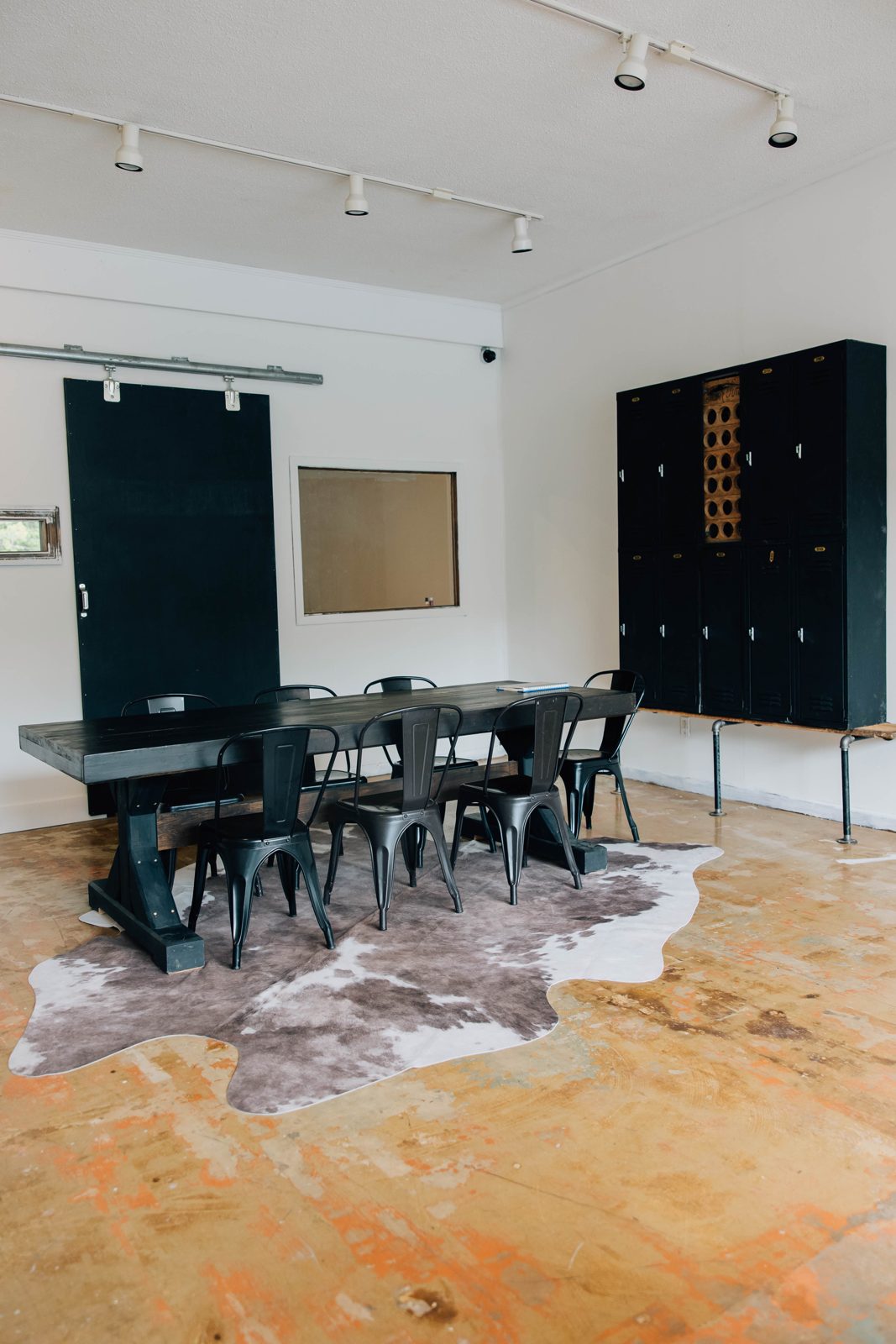 Black conference table with chairs on a cowhide rug